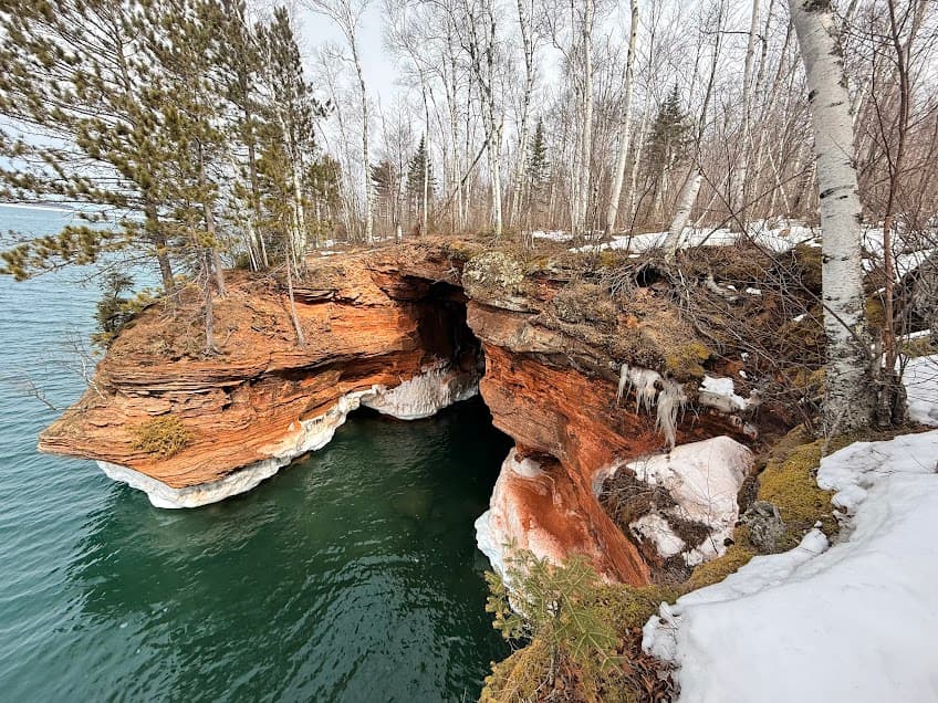 Scene of red sandstone cliffs and ice at the Apostle Islands Sea Caves in Wisconsin.