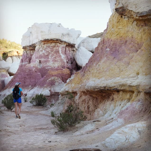 Hiker traverses the hoodoos of the colorful Paint Mines Interpretive Trail in eastern Colorado.